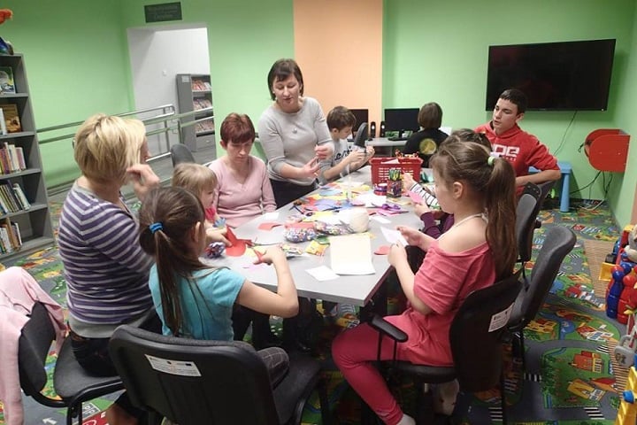Grupa dzieci z opiekunami i bibliotekarką Anią wykonują upominki dla babci i dziadka.