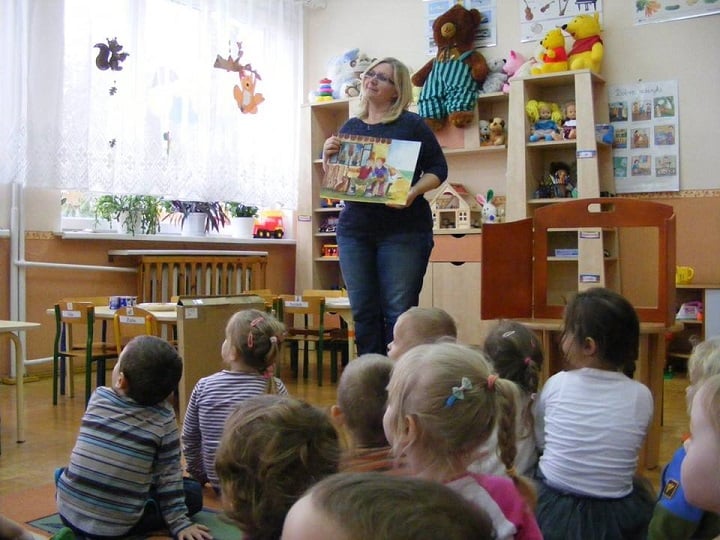 Wnętrze Przedszkola nr 1 , nauczycielka czyta dzieciom bajeczkę o złotej rybce i trzech świnkach. 