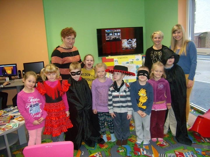 Grupa dzieci podczas zajęć w bibliotece w strojach Zorro i Hiszpańskiej tancerki.
