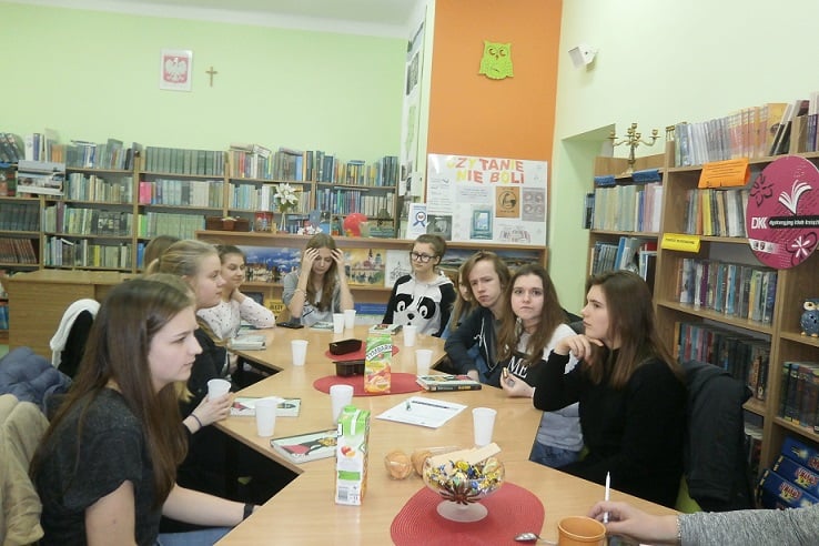Wnętrze biblioteki, przy stolikach siedzą uczestnicy DKK GIM NR2 wspólnie omawiają książkę Eric-Emmanuel Schmitt: "Tajemnica pani Ming".