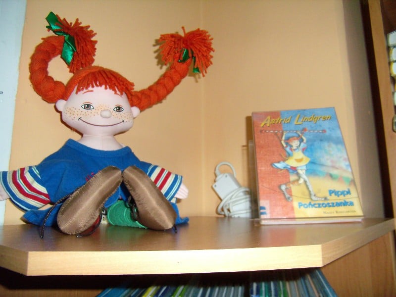 Na stoliku leży maskotka lalka pipilangstrumpf oraz książka Astrid Lindgren Pippi Pończoszanka.
