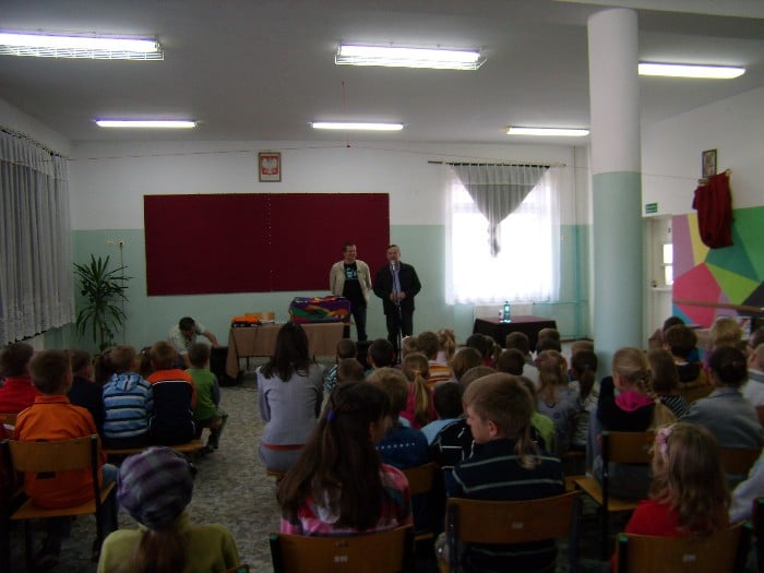 Wnętrze szkoły, grupa dzieci biorąca udział w spotkaniu  z Andrzejem Markiem Grabowskim.