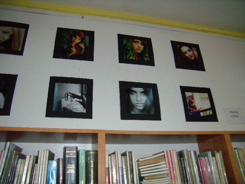 Na ścianie w bibliotece wisi wystawa zdjęć Łukasza Podolskiego. 