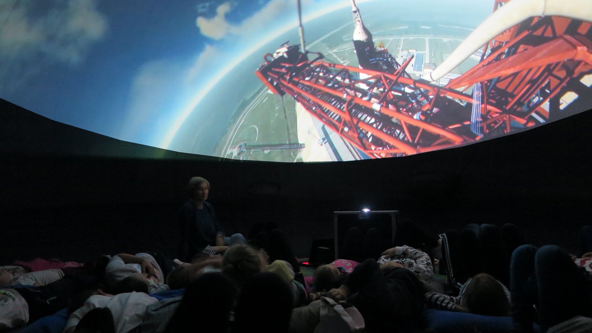 Grupa dzieci ogląda mobilne planetarium,historię podboju księżyca, tajemnice układu słonecznego oraz historię lotów kosmicznych. 