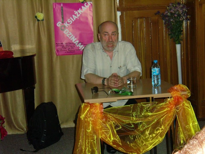 Przy stoliku siedzi pisarz Sławomir Kopr autor książek historycznych.