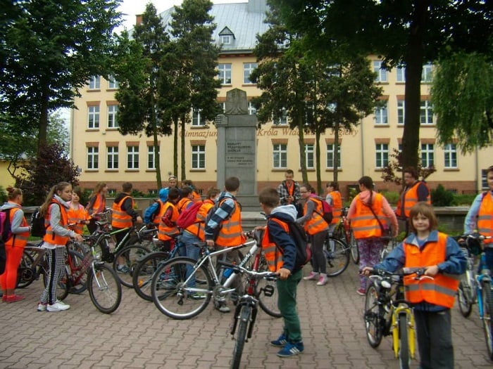 Przed szkołą na placu grupa uczestników rajdu rowerowego  "Odjazdowy Bibliotekarz".