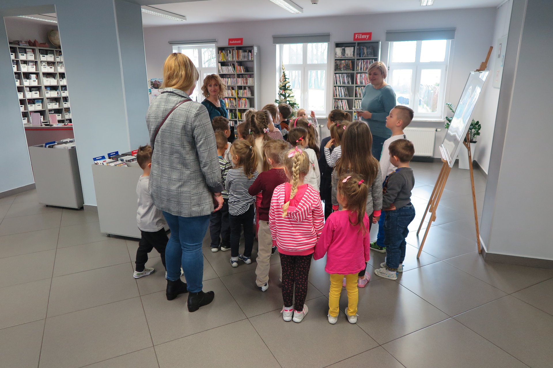Wnętrze biblioteki, mediateka. Bibliotekę odwiedziły dzieci z przedszkola z Księżego Dworu wraz z opiekunkami.