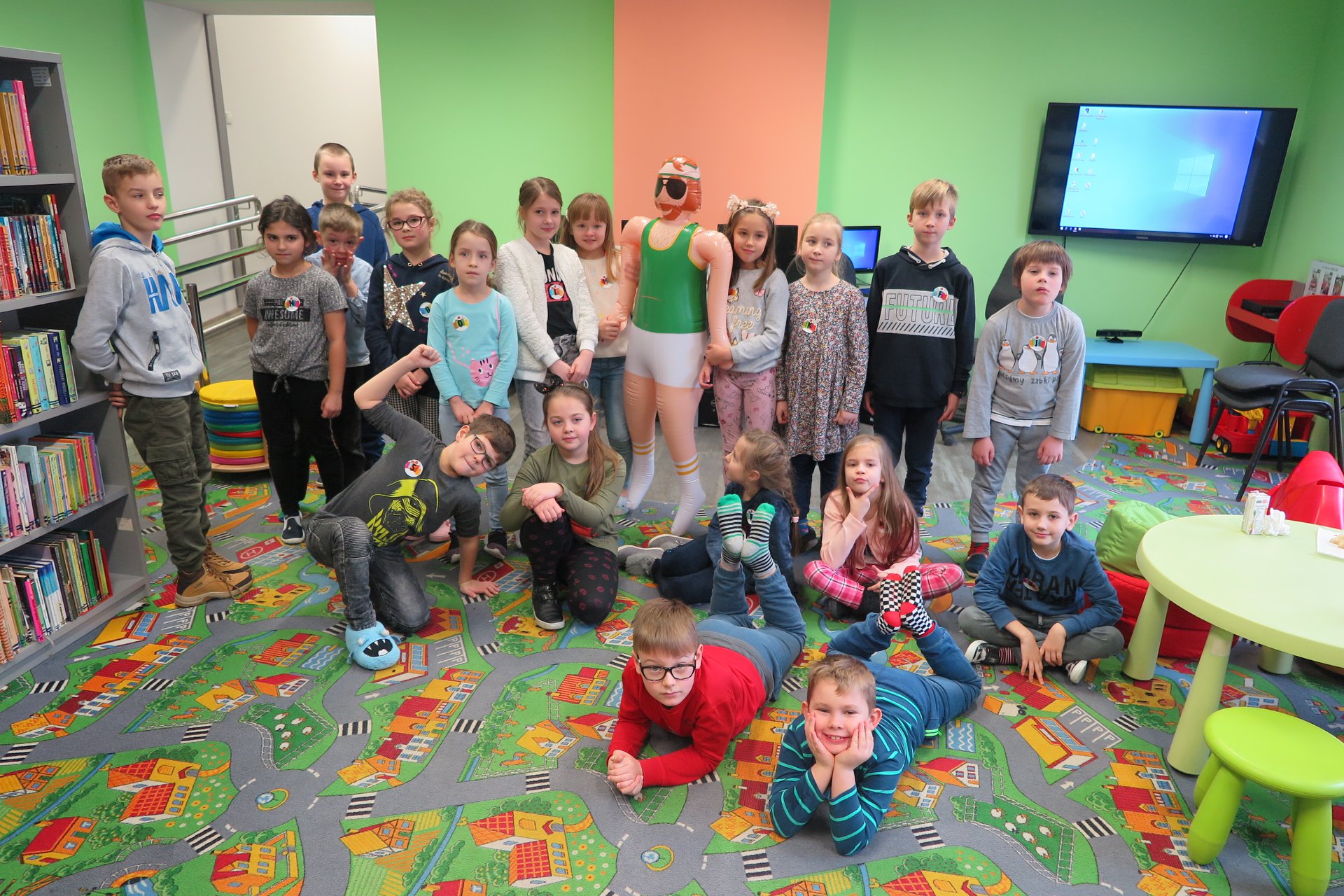 Wnętrze biblioteki, z okazji ferii grupa dzieci bierze udział w ''Fabryce Zimowych Pomysłów w MBP''. 