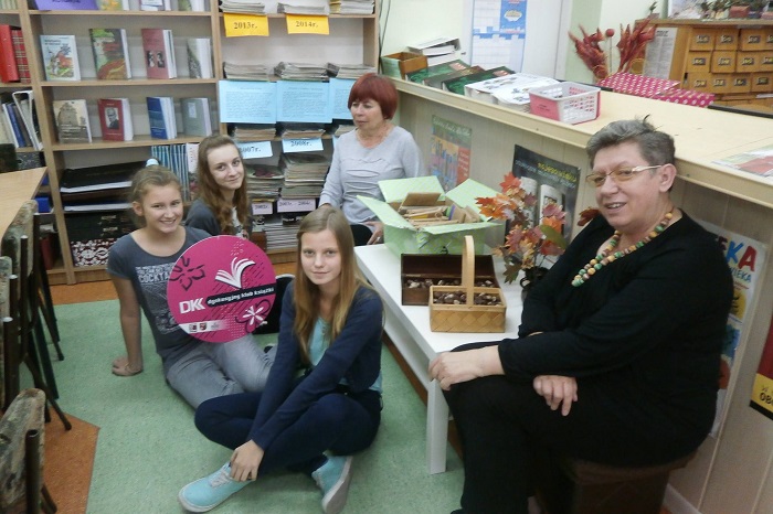 Wnętrze biblioteki, na krzesełkach siedzi pani Ewa Sotomska i Elżbieta Zakrzewska oraz członkinie DKK GIM Nr 2 wspólnie omawiają książkę E.E. Schmitta "Zapasy z życiem".