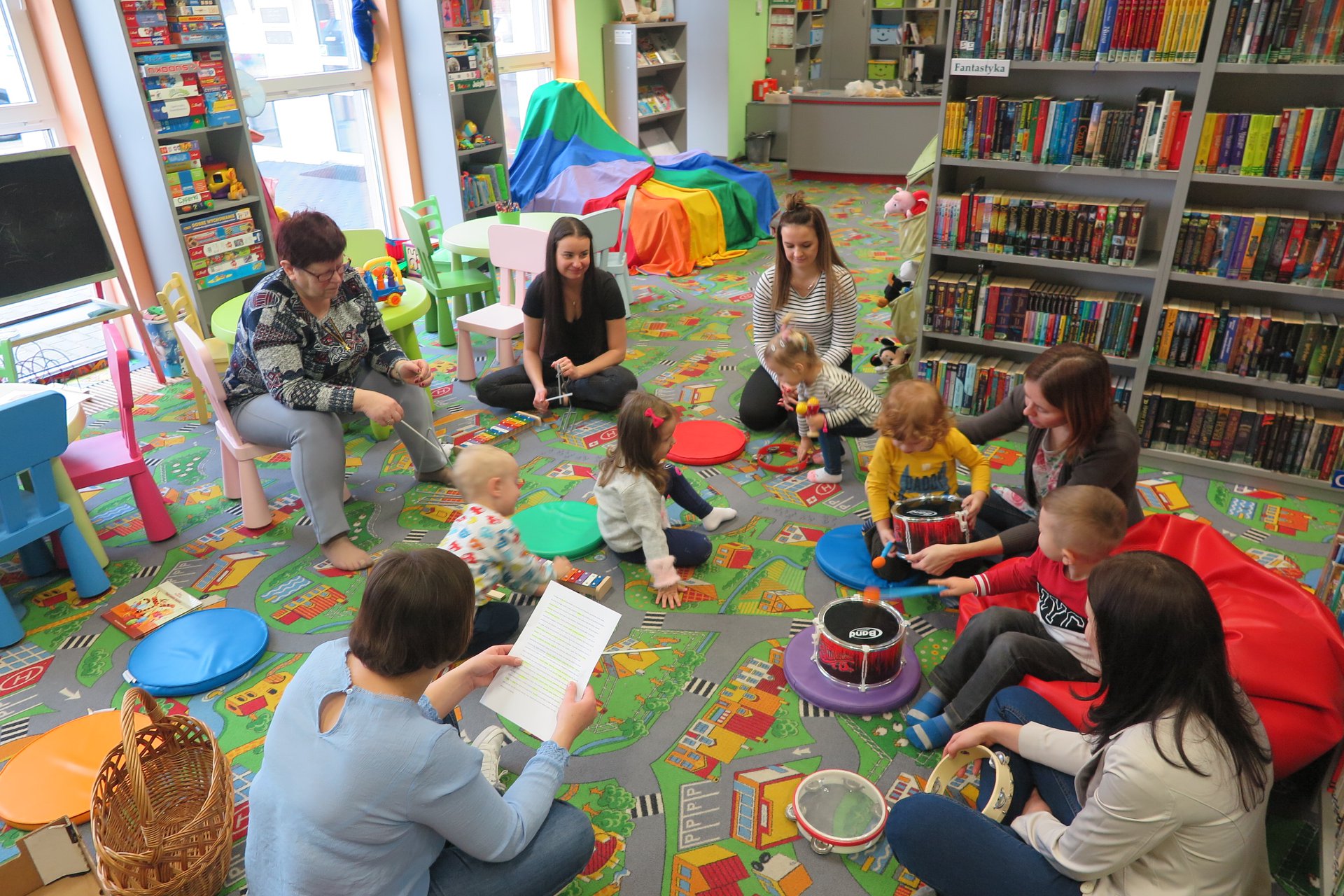 Wnętrze biblioteki (Klub Malucha) bibliotekarka Ania Wiśniewska czyta dzieciom ''Tygrysiastą kapelę''.