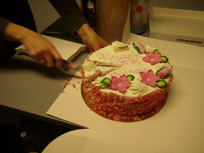 Na stoliku leży tort z napisem Roczek DKK ZS Malinowo.