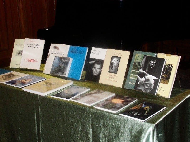 Na stoliku leżą książki różnych poetów z okazji  IV Ogólnopolskiego Konkursu Poetyckiego. 