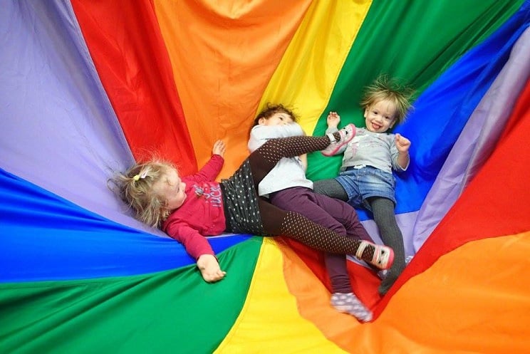 W kolorowej chuście bawią się dzieci z Klubu Malucha.