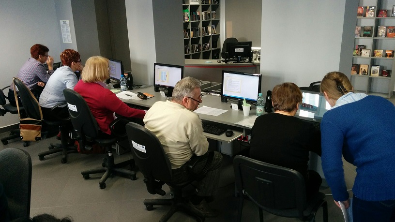 Pięcioro uczestników siedzi przy stanowiskach z komputerami, wszyscy biorą udział w 7 edycji kursu z podstawowej obsługi komputera. 