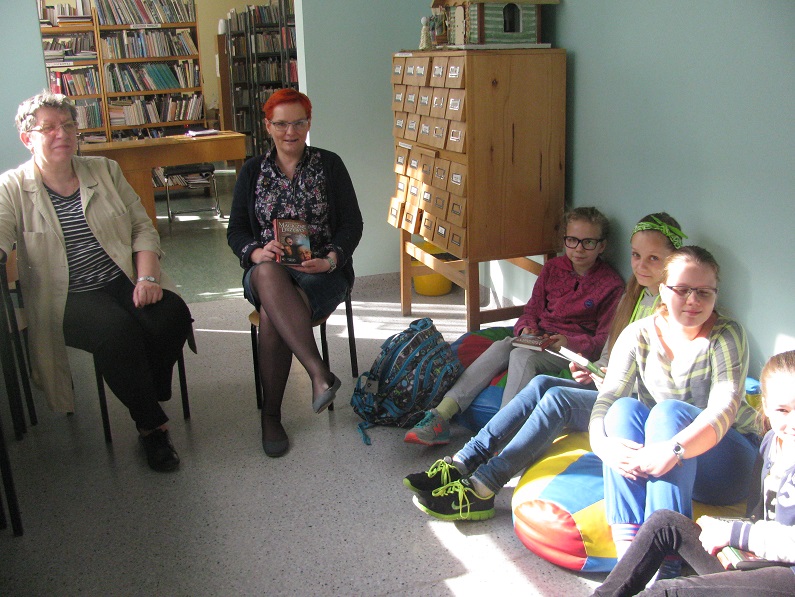 Wnętrze biblioteki, uczestnicy DKK SP 3 wspólnie omawiają książkę A. Maleszka "Magiczne drzewo".