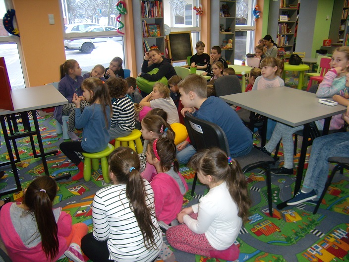 Grupa dzieci podczas zabawy w bibliotece.