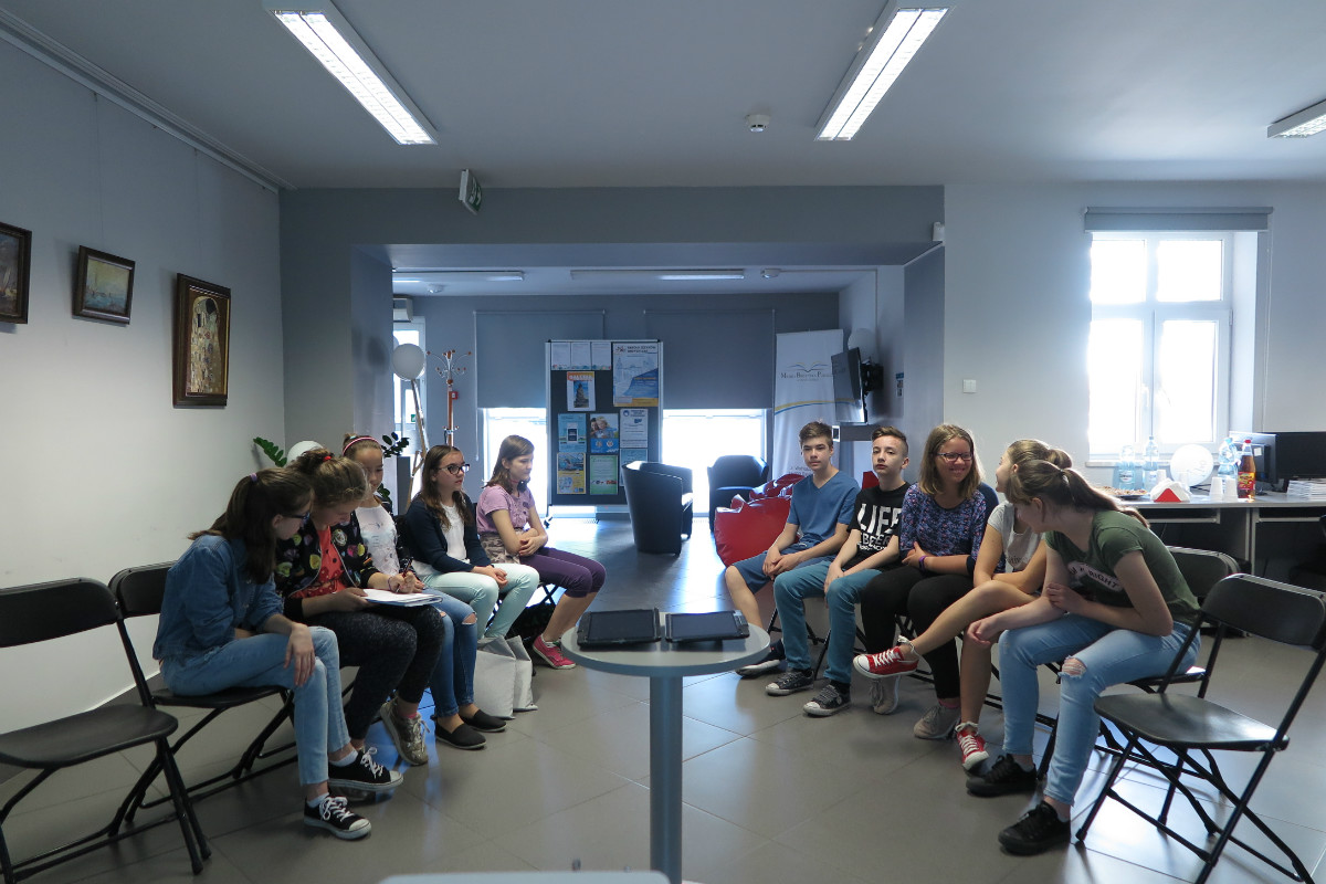 Wnętrze biblioteki,mediateka. Grupa uczniów ze SP i Gimnazjum biorą udział w Europejskiej Familiadzie.