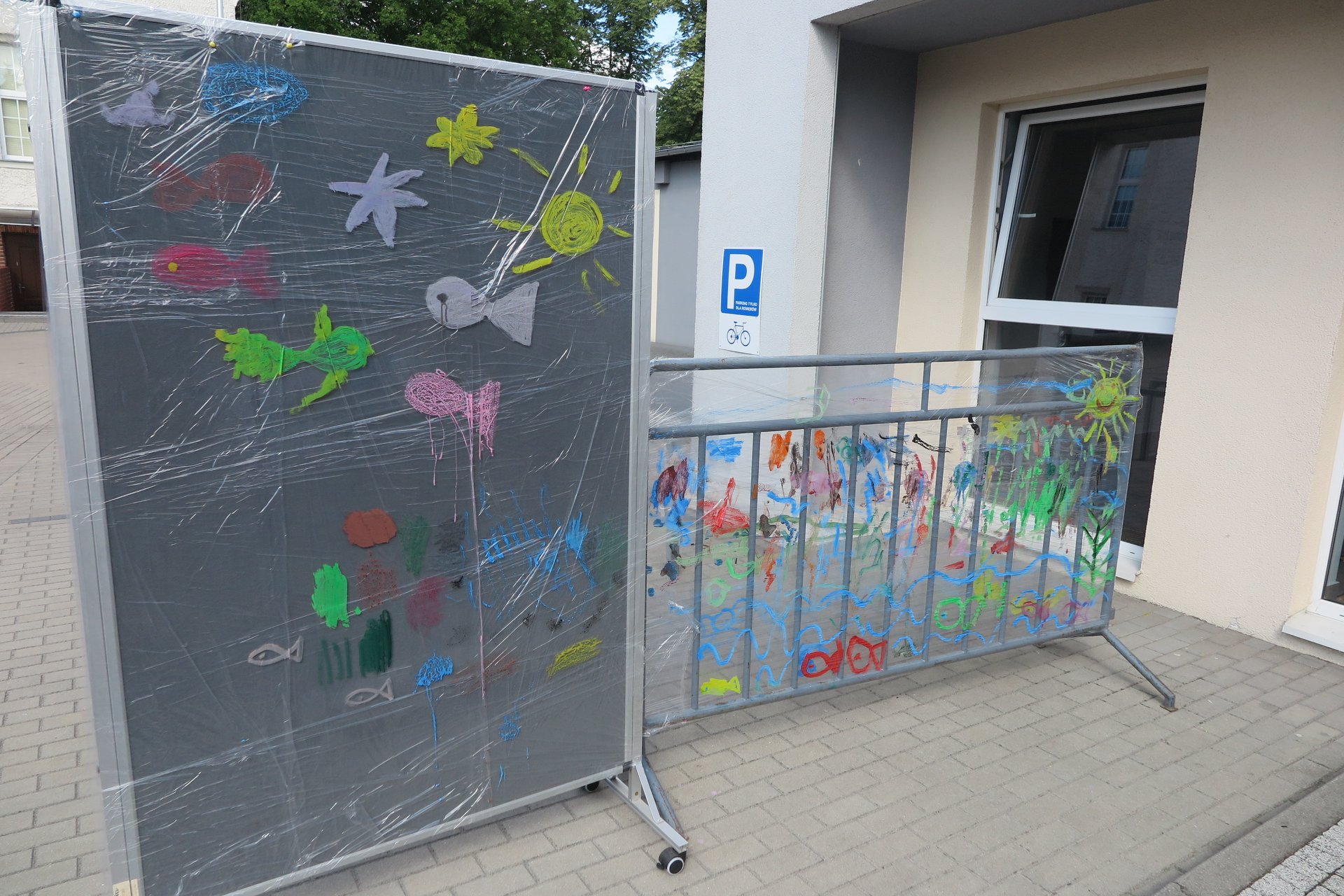 Przed biblioteką w Działdowie namalowane na folii motywy morskie przez dzieci. 