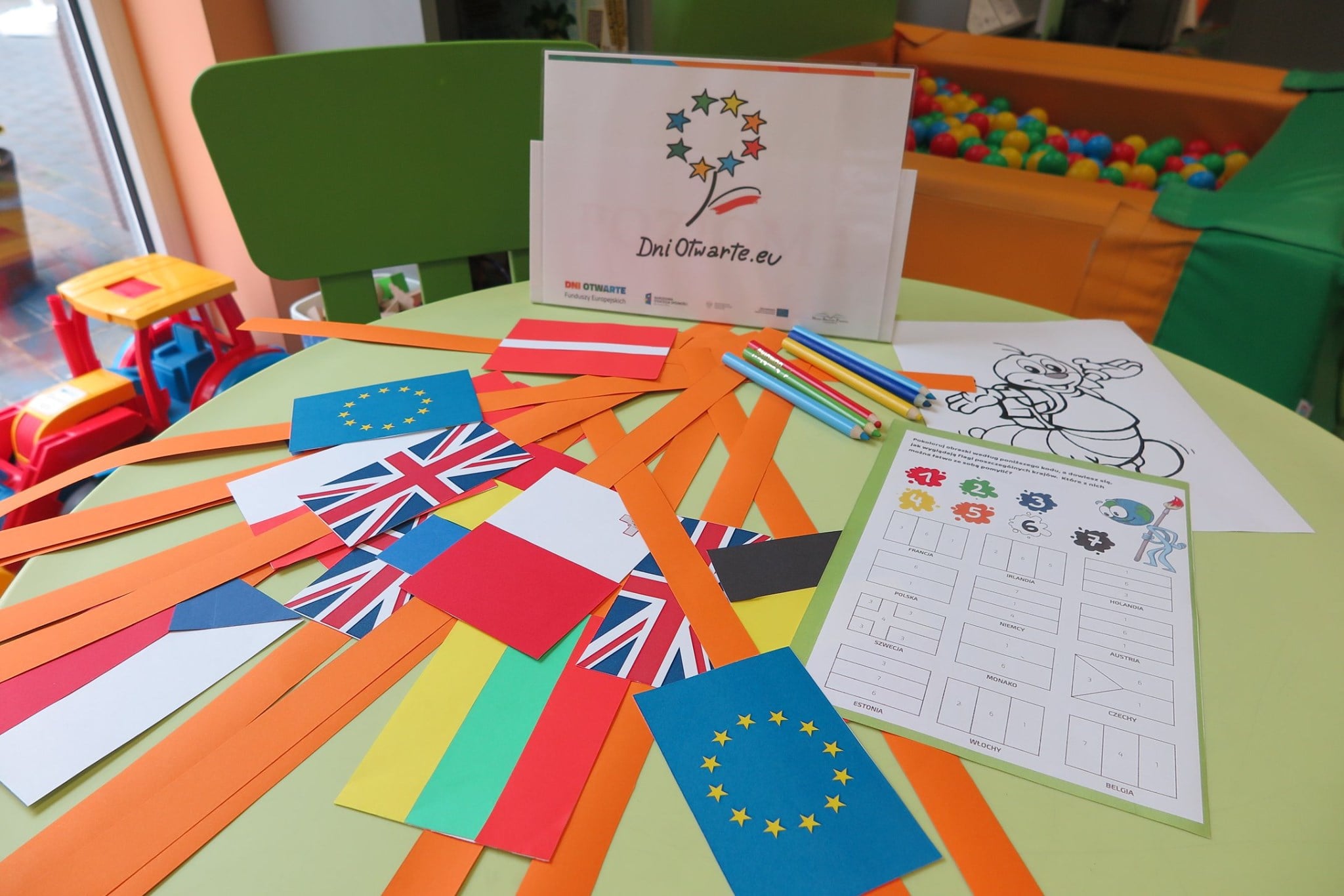 Na stoliku wycięte flagi krajów UE i inne elementy związane z UE.  