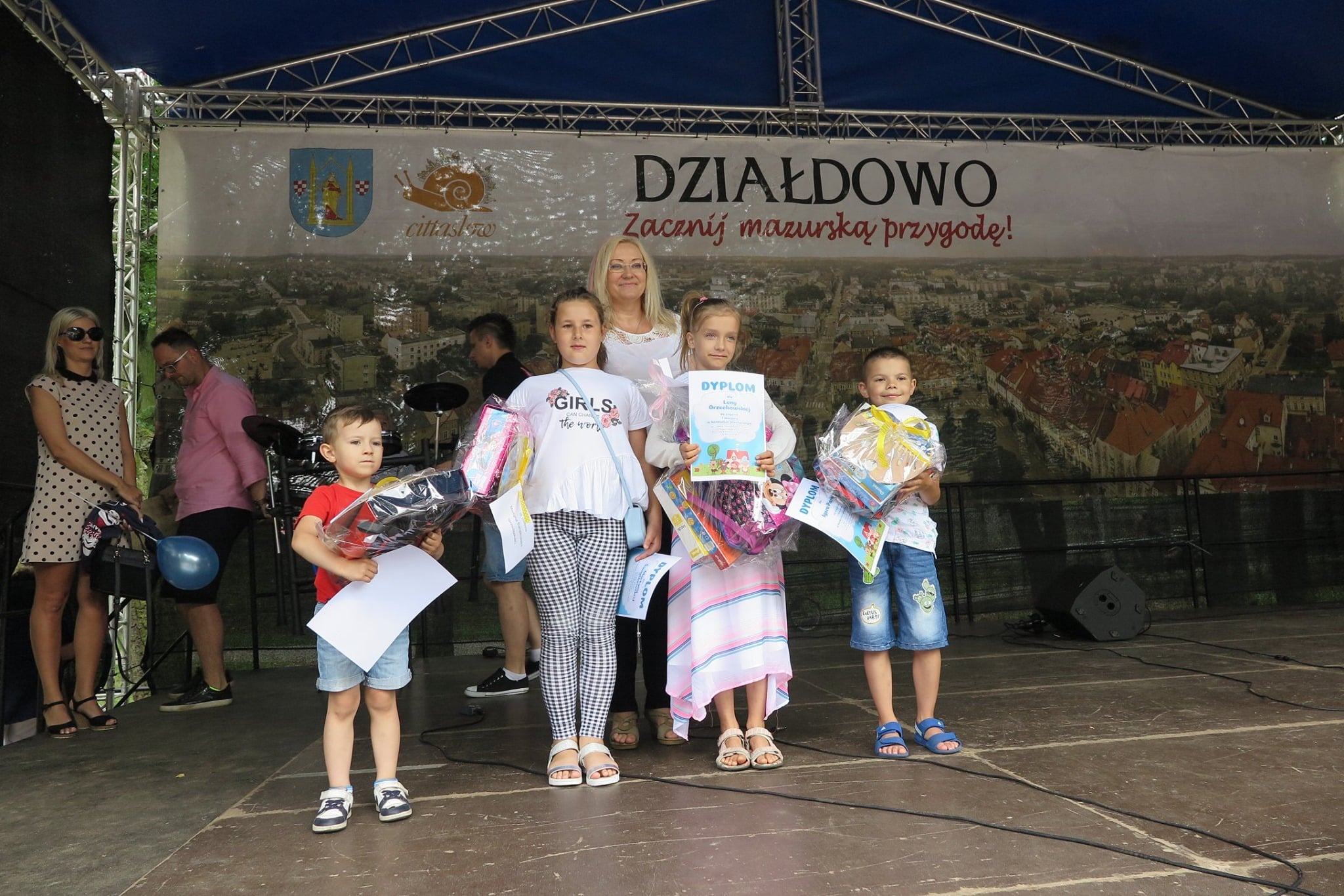W parku na scenie dyrektor MBP Justyna Lytvyn i czworo dzieci z dyplomami. 