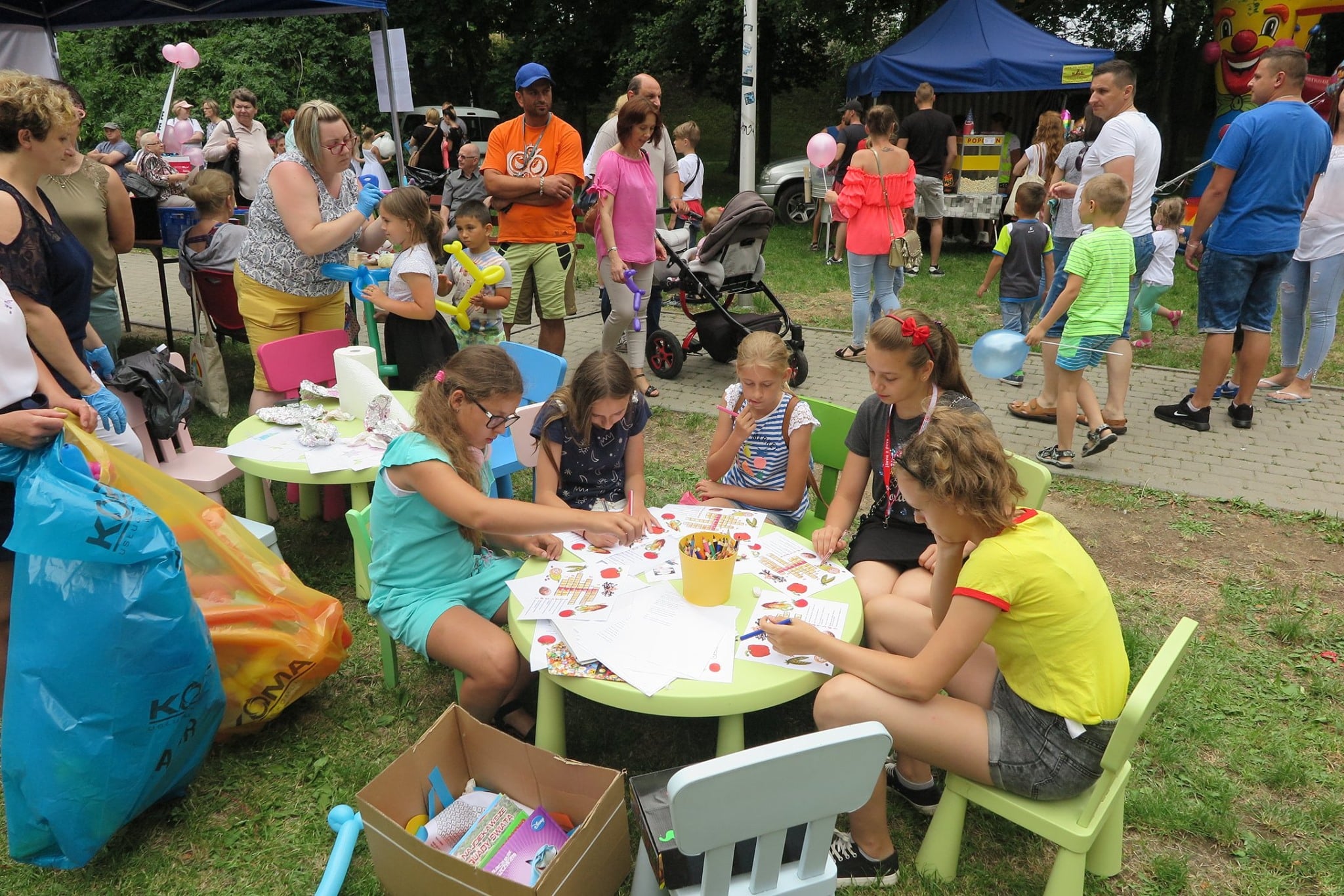 Festyn ''Wstąp po zdrowie'' przy stolikach dzieci wykonują prace plastyczne. 