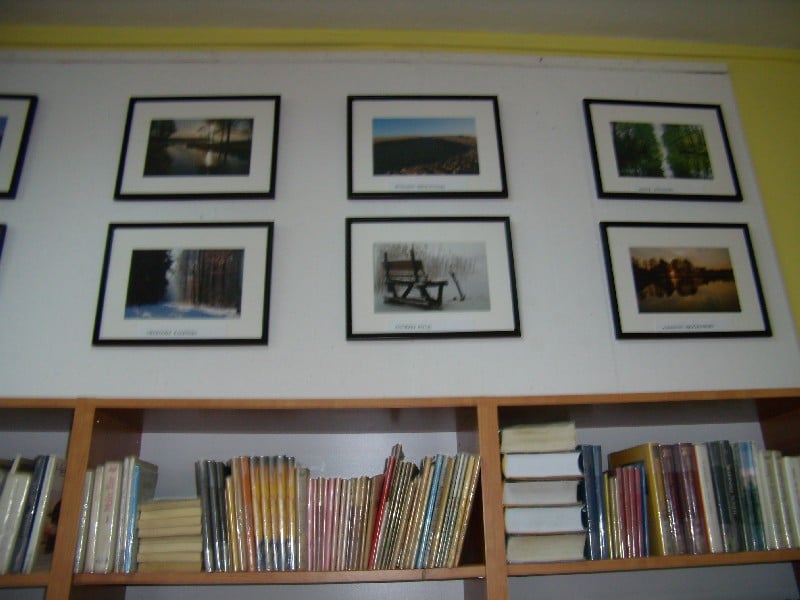 Wnętrze biblioteki,na ścianie wiszą obrazy fotografii ,,Powiat Działdowski w moim obiektywie''. 