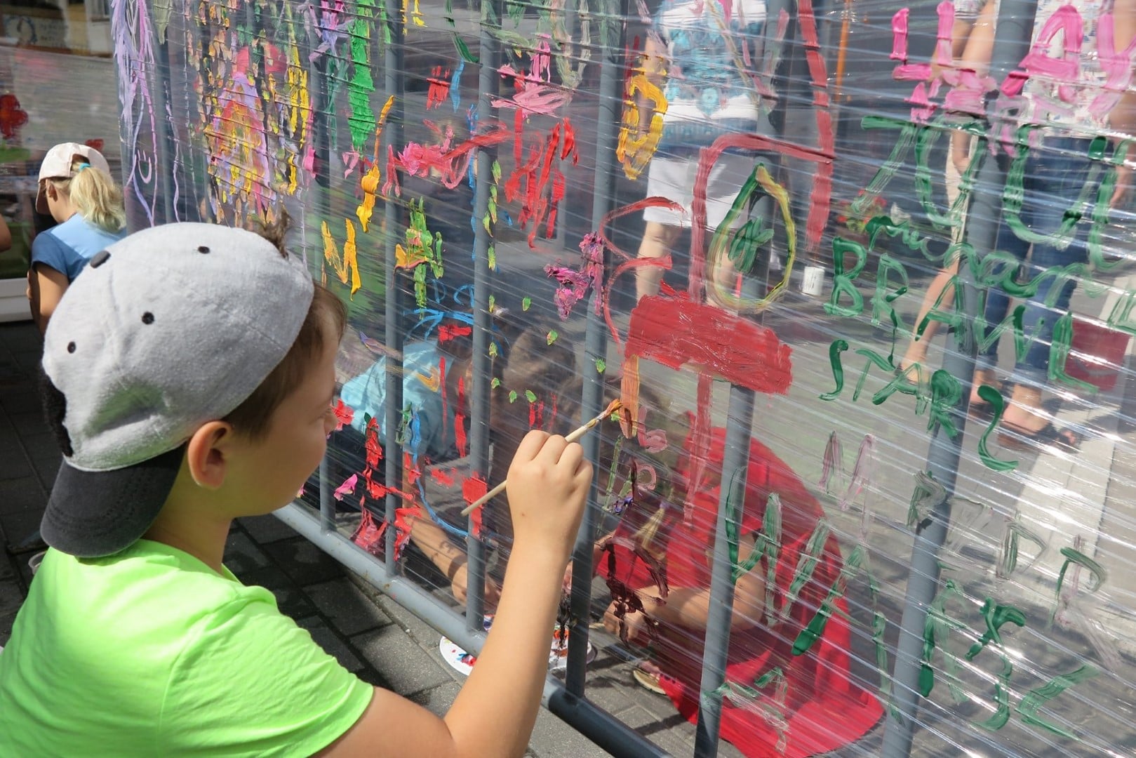 Na placu MBP chłopiec maluje farbkami na folii. 