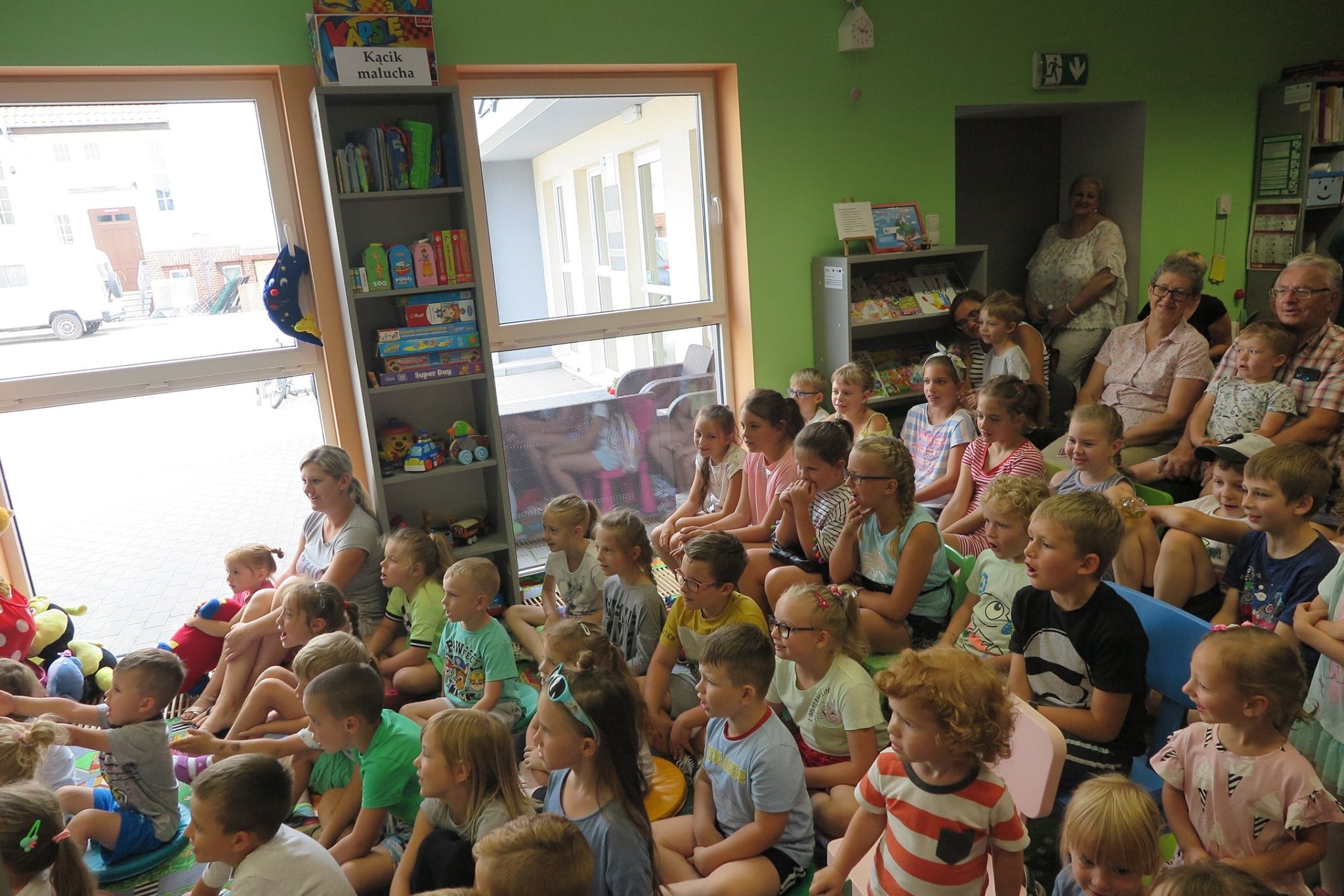 Wnętrze biblioteki. Dzieci oglądają przedstawienie „Prastara  Książnica-Skarb i Tajemnica” Teatru  Edukacji i Profilaktyki „Maska” z Krakowa.