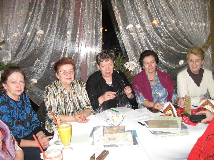Przy stolikach siedzą członkowie DKK UTW wspólnie omawiają książkę E. Sukertowej-Biedrawiny "Diabeł na Mazurach w baśniach i podaniach".