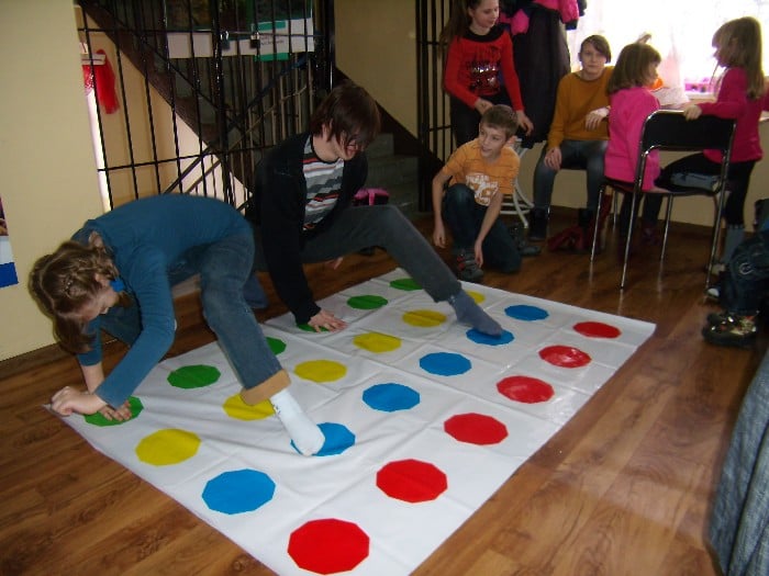 Wnętrze biblioteki, grupa dzieci gra w grę kolorowe pola.