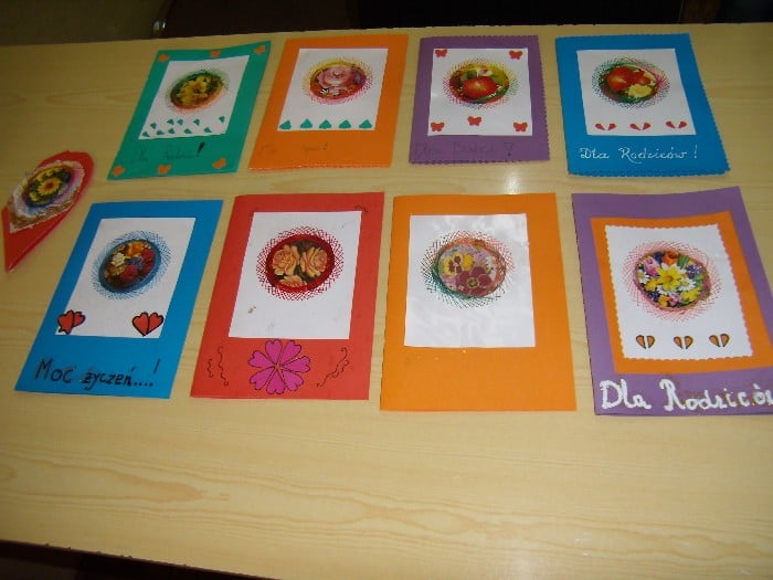 Na stoliku leży osiem kartek z życzeniami dla rodziców.