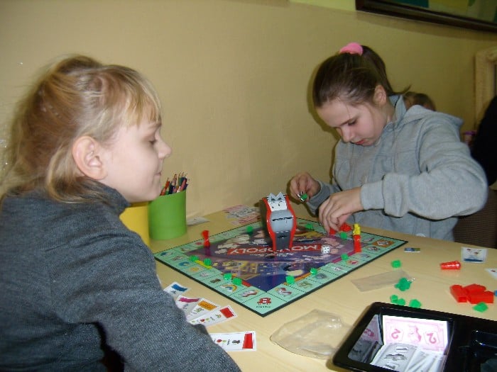 Dwie dziewczynki grają w grę monopol.