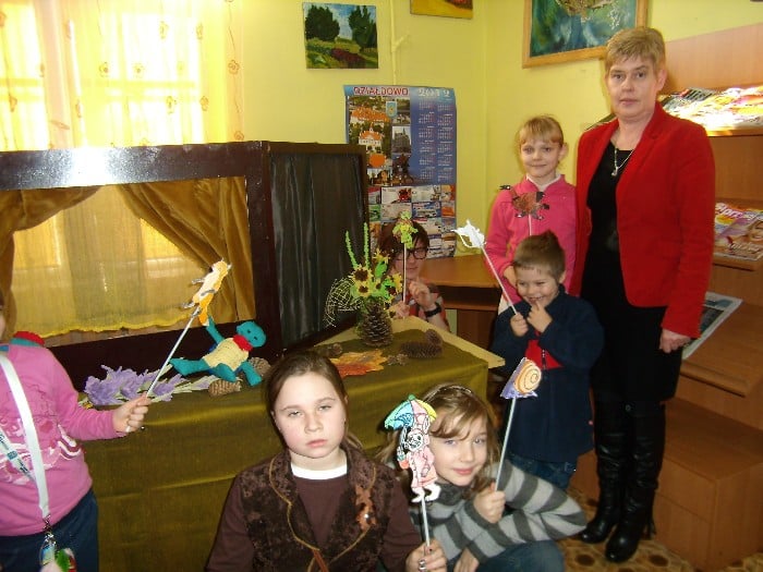 Bibliotekarka Marzena Pawłowska z dziećmi podczas ferii w bibliotece.