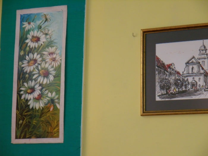 Wnętrze biblioteki na ścianie wiszą obrazy Lucyny i Jana Mielke.