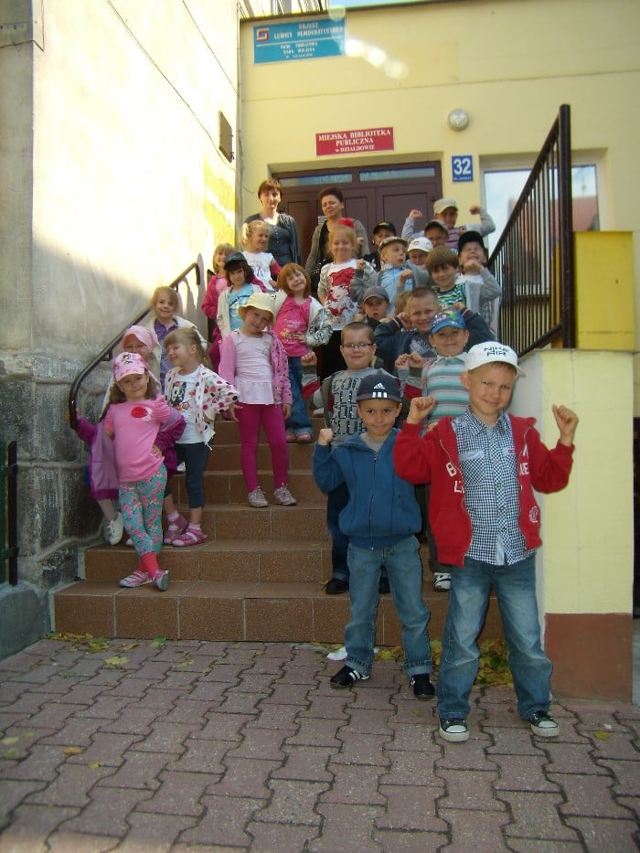 Na schodach przed MBP w Działdowie grupa dzieci z opiekunkami.