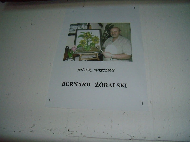 Plakat ze zdjęciem autora wystawy Bernarda Żóralskiego.
