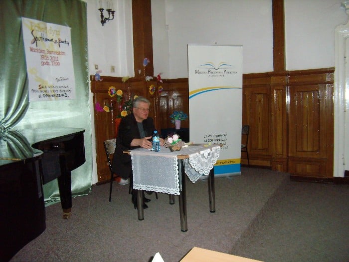 Wnętrze szkoły muzycznej, przy stoliku Marek Barański redaktor Gazety Olsztyńskiej.