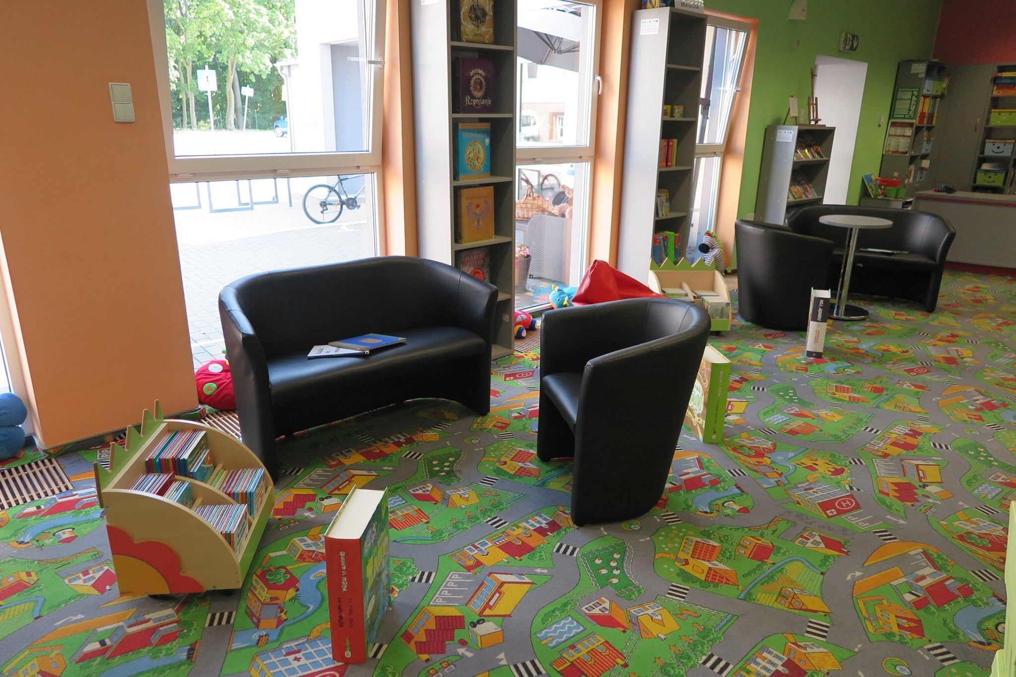 Wnętrze biblioteki, oddział dla dzieci. W tle kanapy i fotele oraz regały z książkami.