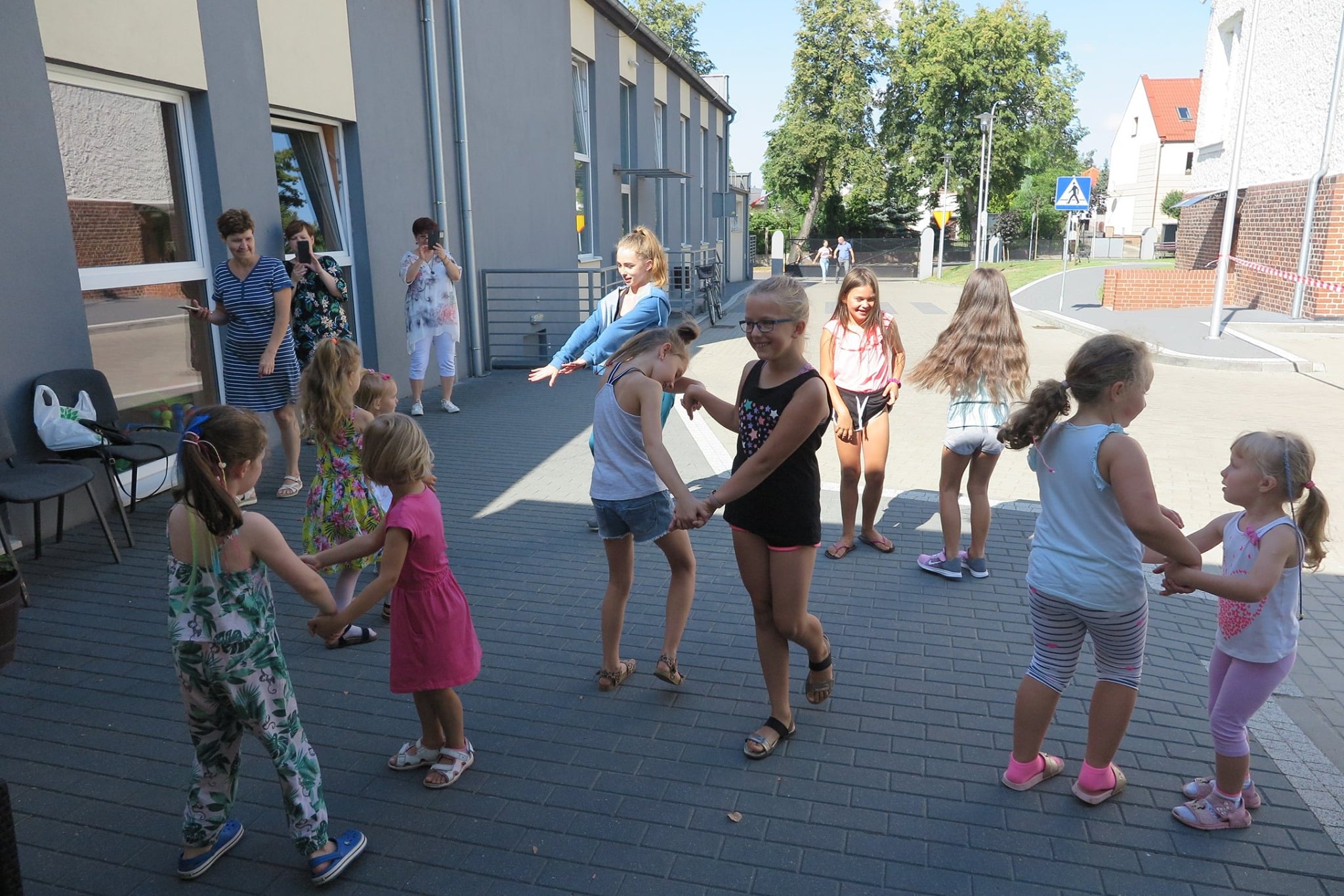 Plac przed MBP w Działdowie, dzieci tańczą do znanych wakacyjnych przebojów.