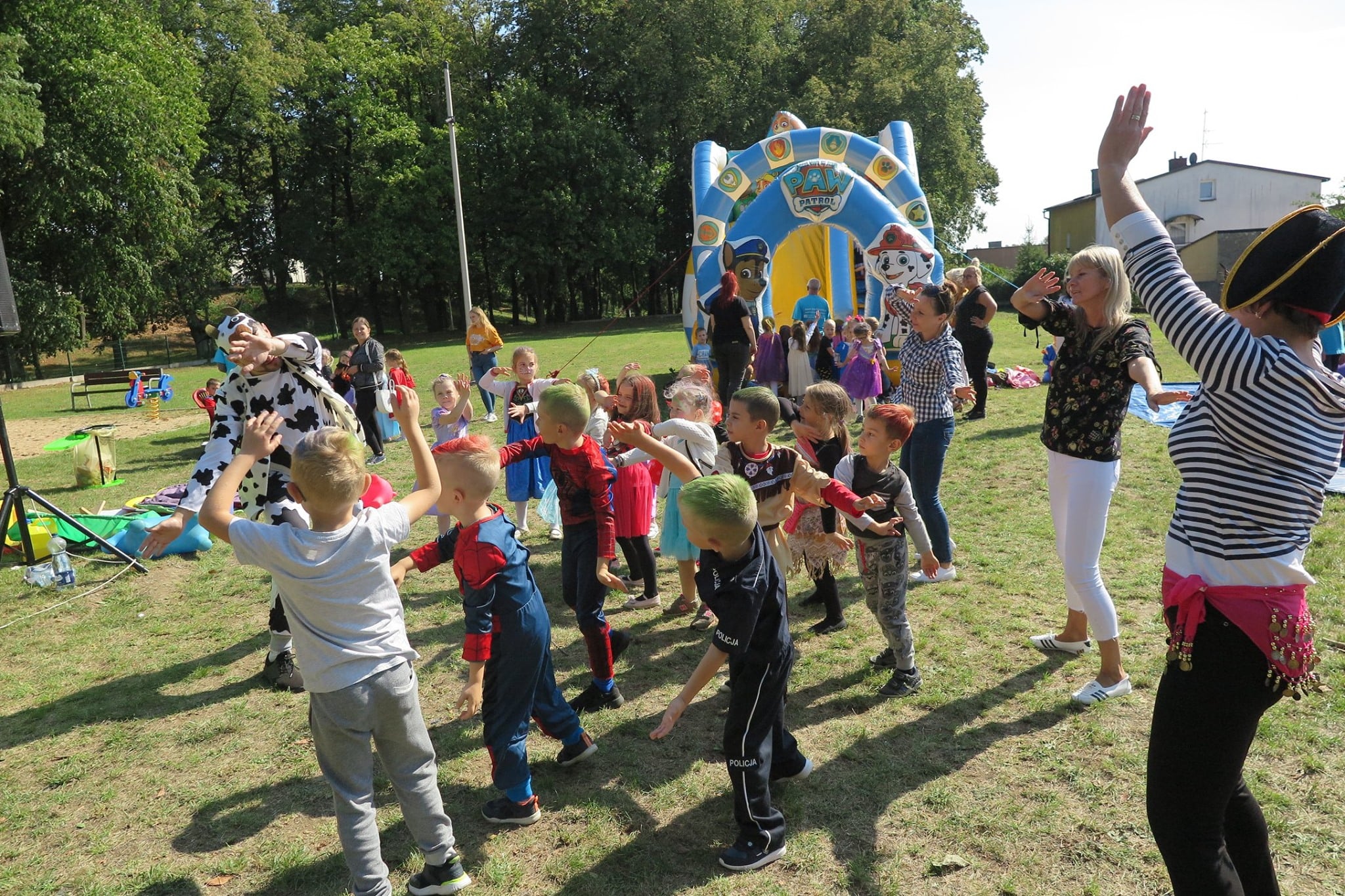 Duża liczba dzieci bawi się i tańczy na placu obok MBP z okazji ''Parady Postaci Bajkowych''.