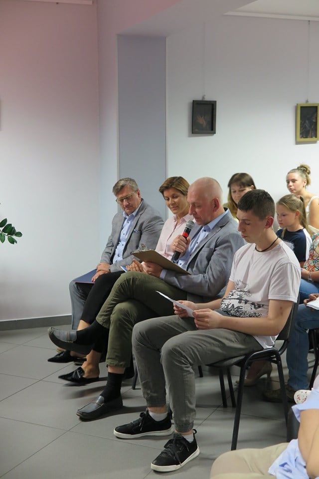 Na krzesełkach goście, przybyli na Narodowe Czytanie przy mikrofonie burmistrz miasta Działdowo Grzegorz Mrowiński.