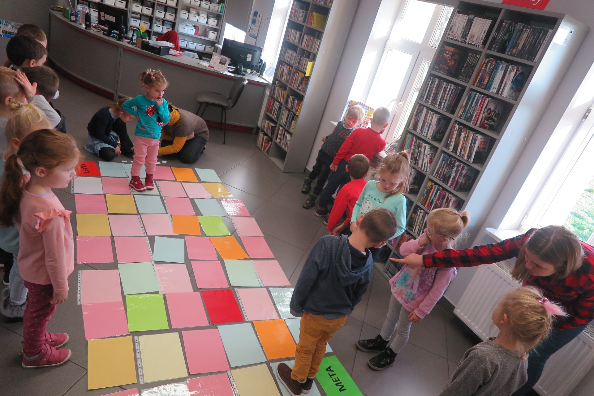 Wnętrze biblioteki,mediateka. Przedszkolaki z grupy ''Tygryski'' z przedszkola ''U Misia'' grają w grę owocowo-warzywną z programowania.