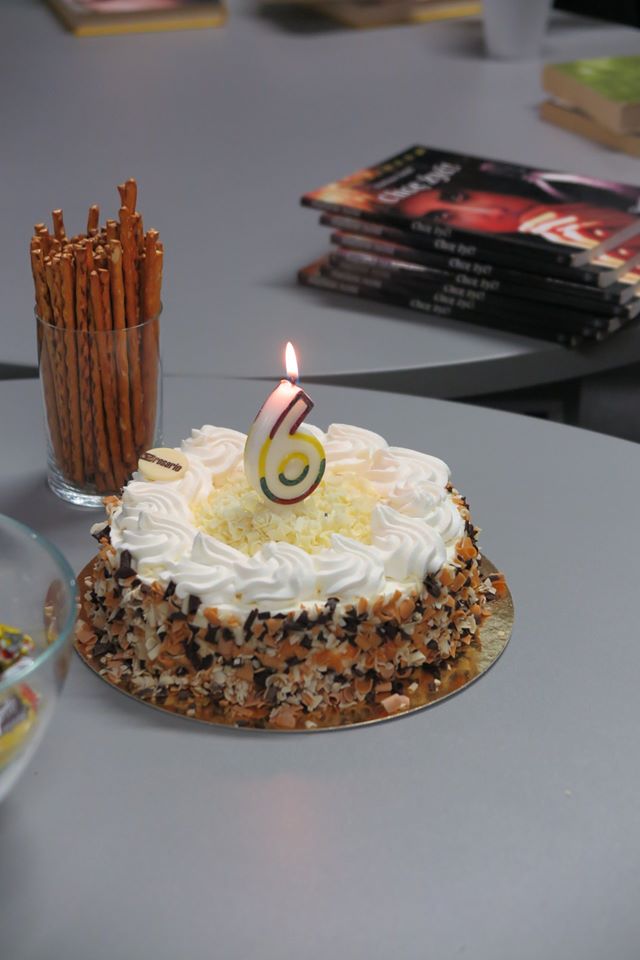 Na stoliku tort ze świecą z okazji 6 rocznicy istnienia klubu DKK ZS Malinowo.