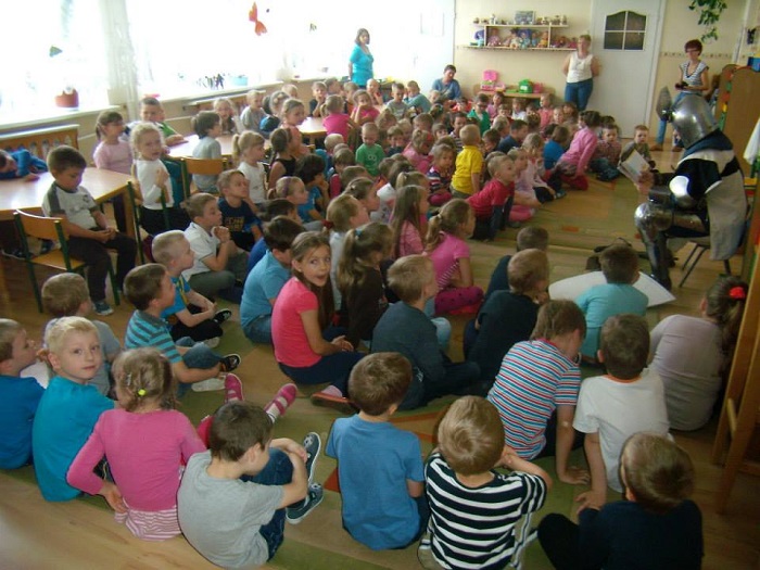 Wnętrze przedszkola grupa dzieci z rycerzem z Bractwa św. Katarzyny Michałem Pawelskim w Miejskim Przedszkolu nr 1.