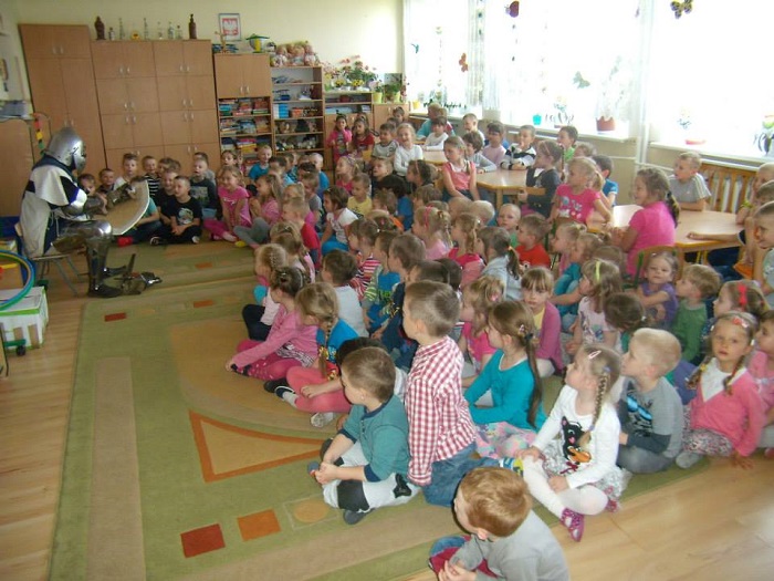 Wnętrze przedszkola grupa dzieci z rycerzem z Bractwa św. Katarzyny Michałem Pawelskim w Miejskim Przedszkolu nr 1.