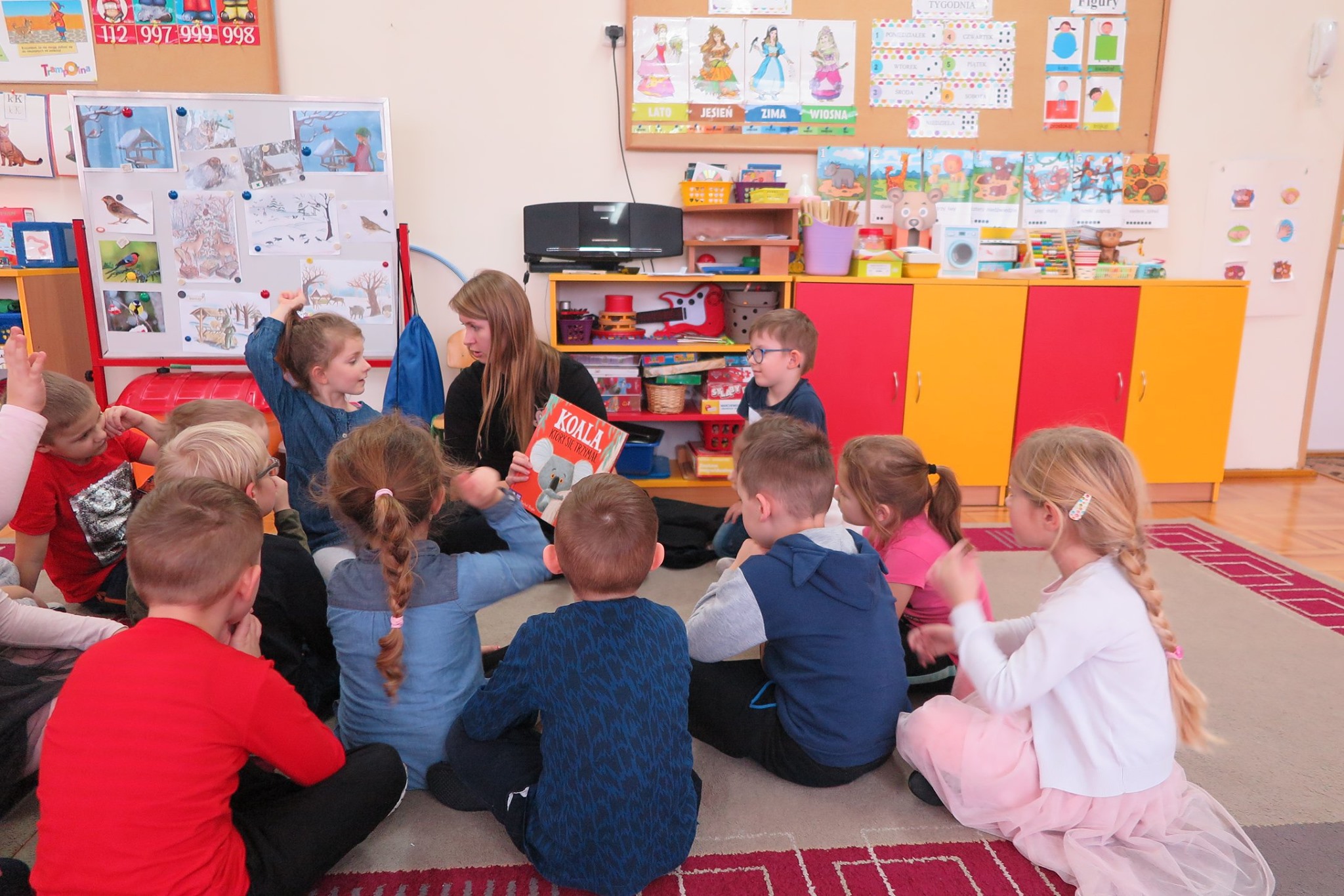 Dzieci z przedszkola nr 1 w Działdowie. Bibliotekarka Aleksandra Cybulska prowadzi zajęcia w przedszkolu. Czyta opowiadanie o koali, który nie potrafił przestać trzymać się drzewa.