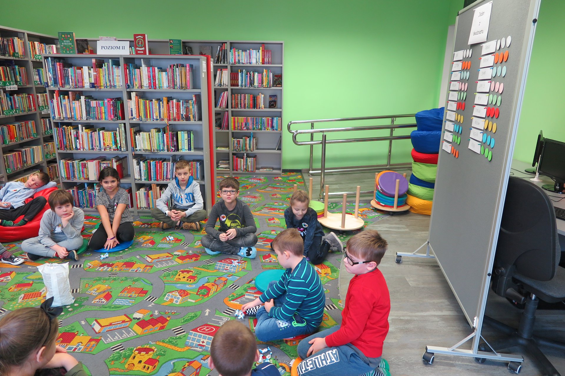 Wnętrze biblioteki, z okazji ferii grupa dzieci bierze udział w ''Fabryce Zimowych Pomysłów w MBP''. 