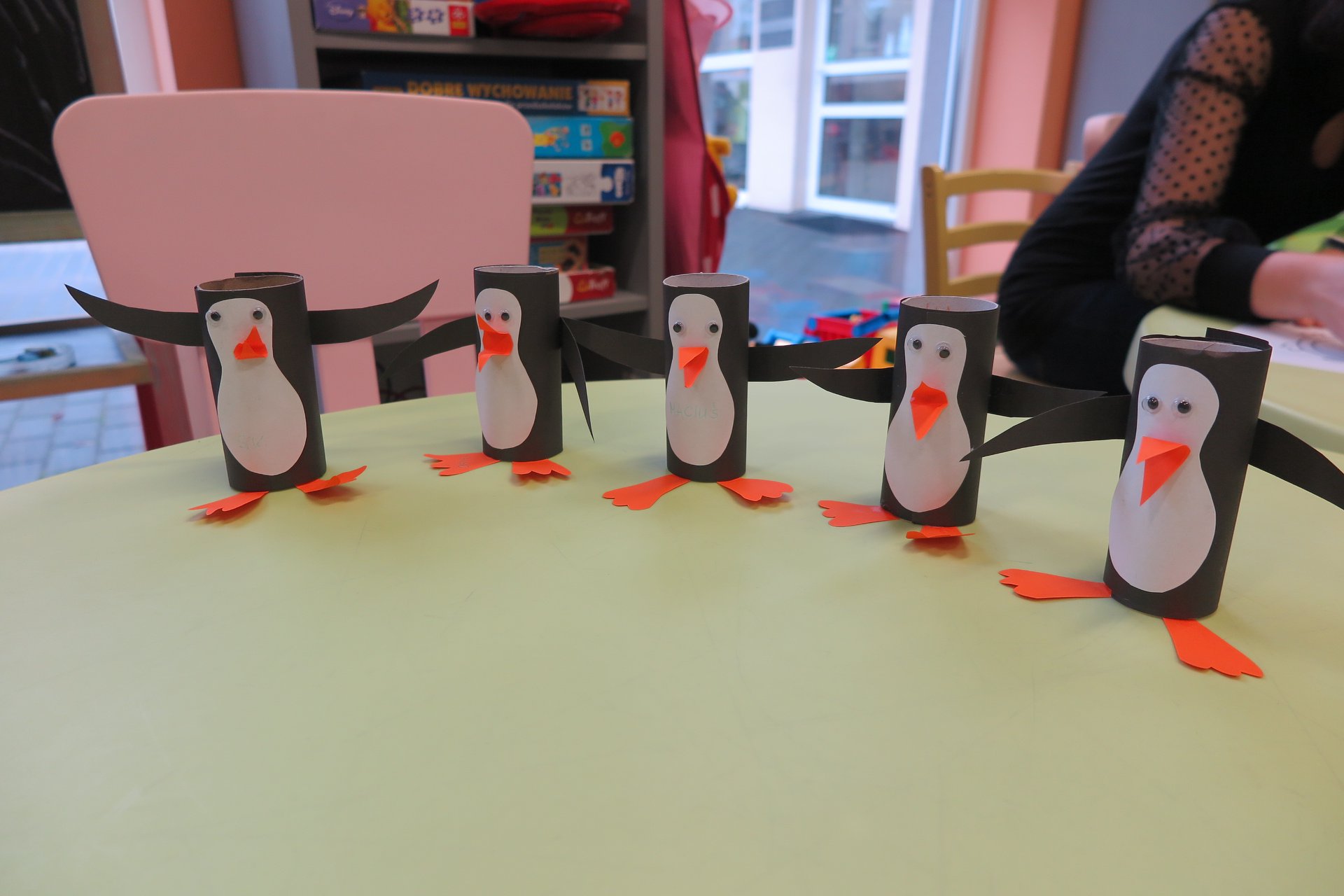 Na stoliku 5 pingwinów wykonanych przez dzieci z tekturowych rolek.