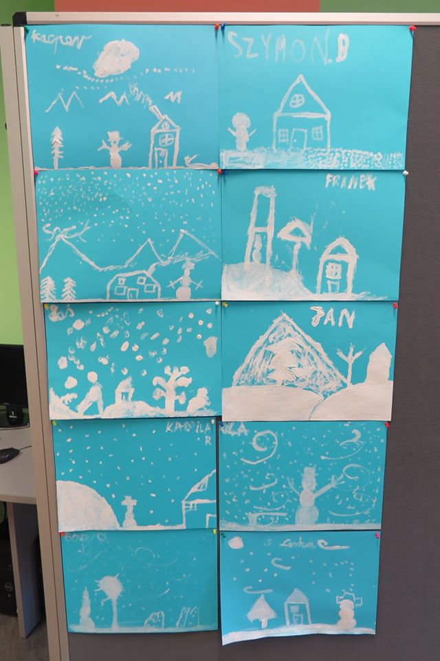 Wnętrze biblioteki,warsztaty plastyczne. Na banerze wisi 10 zimowych krajobrazów wykonanych przez dzieci. 