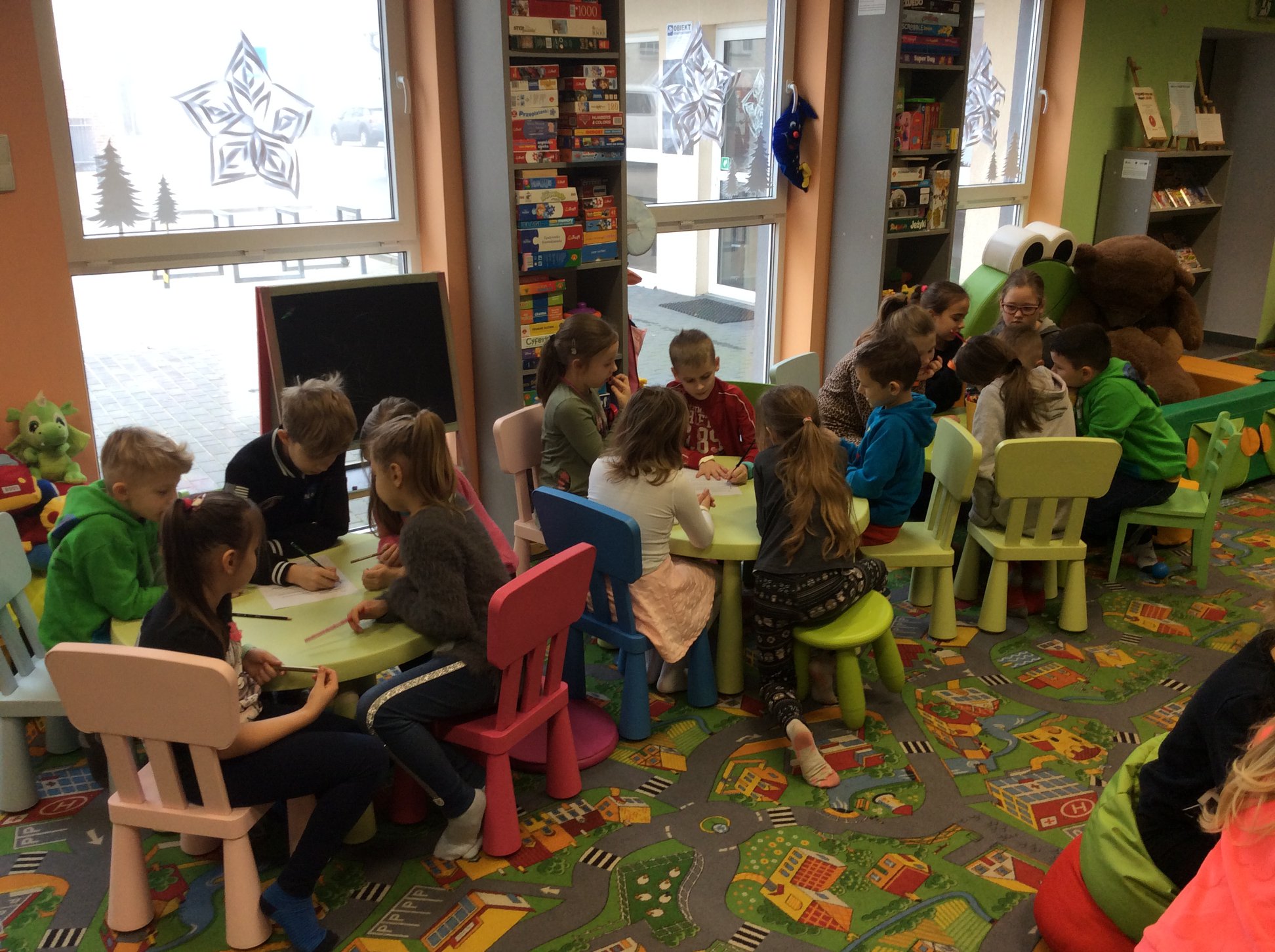 Wnętrze biblioteki, uczniowie klasy II C ze Szkoły Podstawowej nr 2 przybyli na lekcję biblioteczną na temat legend. Zajęcia prowadzi bibliotekarka Aleksandra Cybulska. Dzieci rozwiązują quiz na temat znajomości legend polskich.